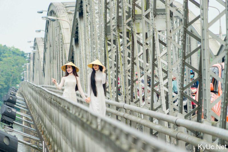 2 cô gái với chiếc áo dài trắng đi trên cầu Trường Tiền